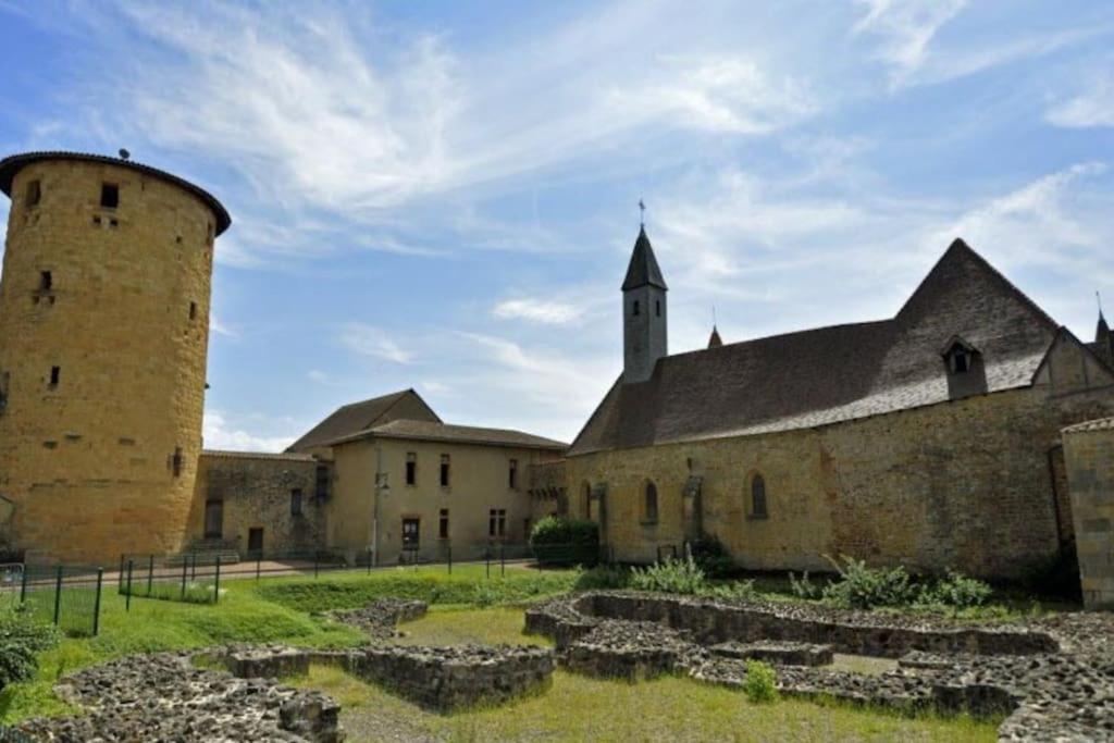 an old building with a tower and a church at Le Petit Grenette in Charlieu