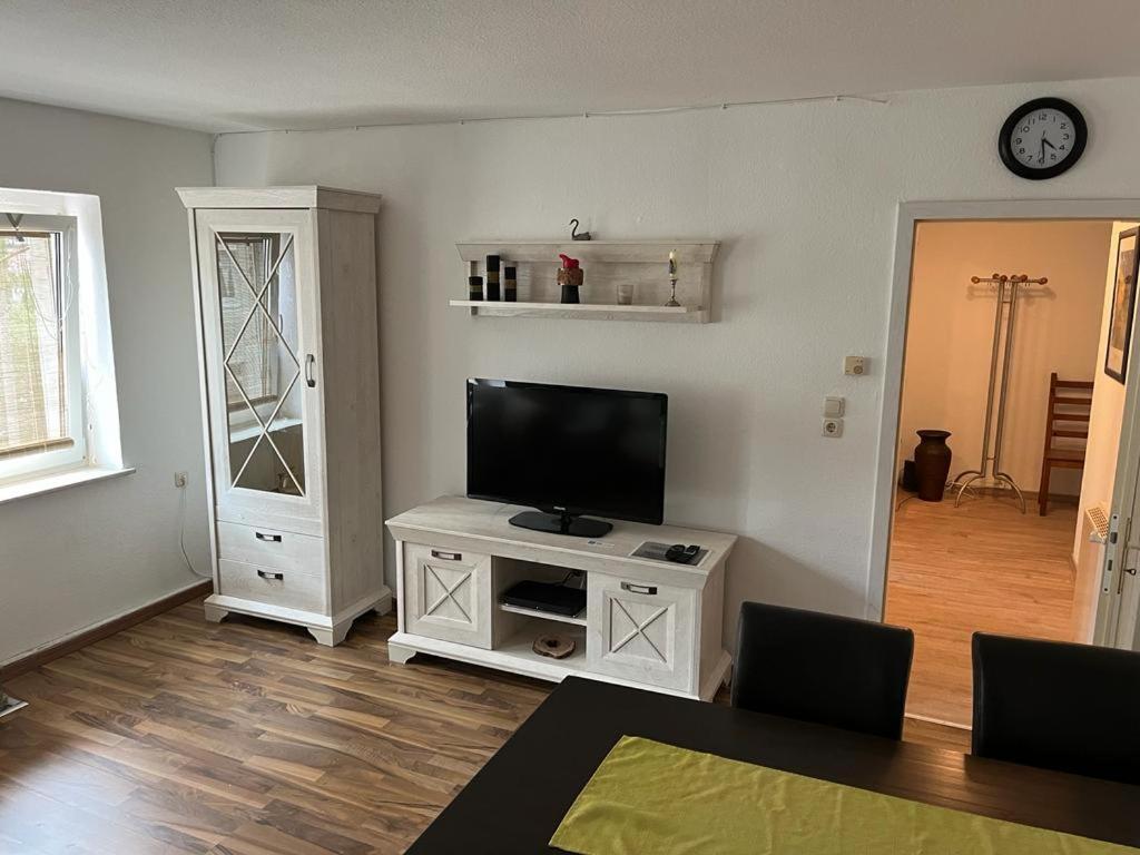 a living room with a flat screen tv on a white cabinet at Pension Rudolph Riesa in Riesa