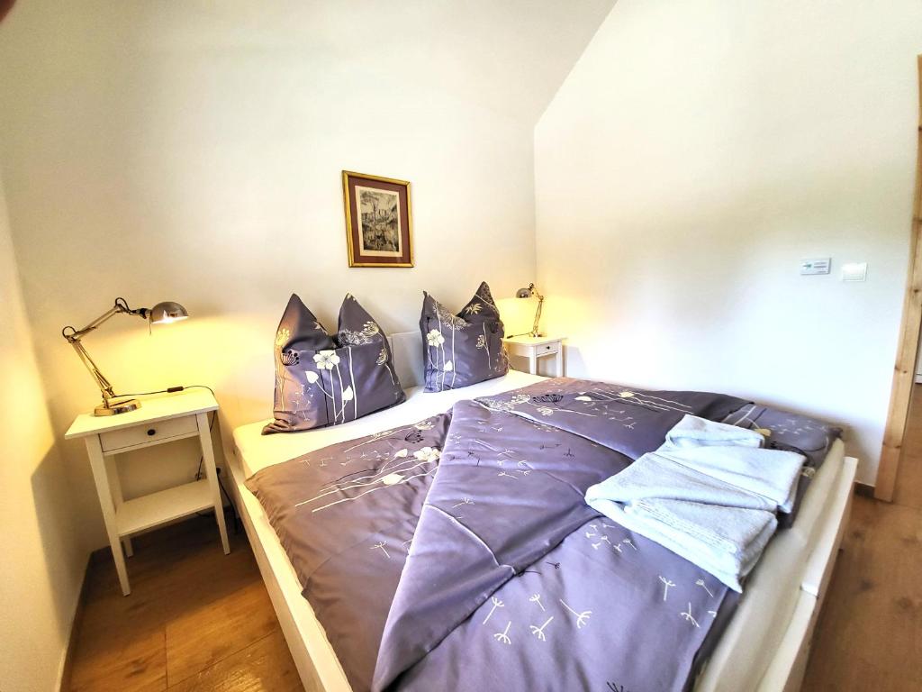 Schlafzimmer mit einem Bett mit lila Bettwäsche und Kissen in der Unterkunft Villa Agardy 1 in Balatonkenese