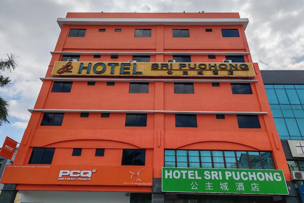 un edificio de hotel naranja con un cartel en él en Hotel Sri Puchong Sdn Bhd, en Puchong