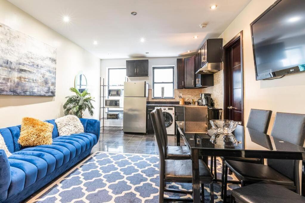 a living room with a blue couch and a table at 3 Bed Modern Apt in Prime Location in New York