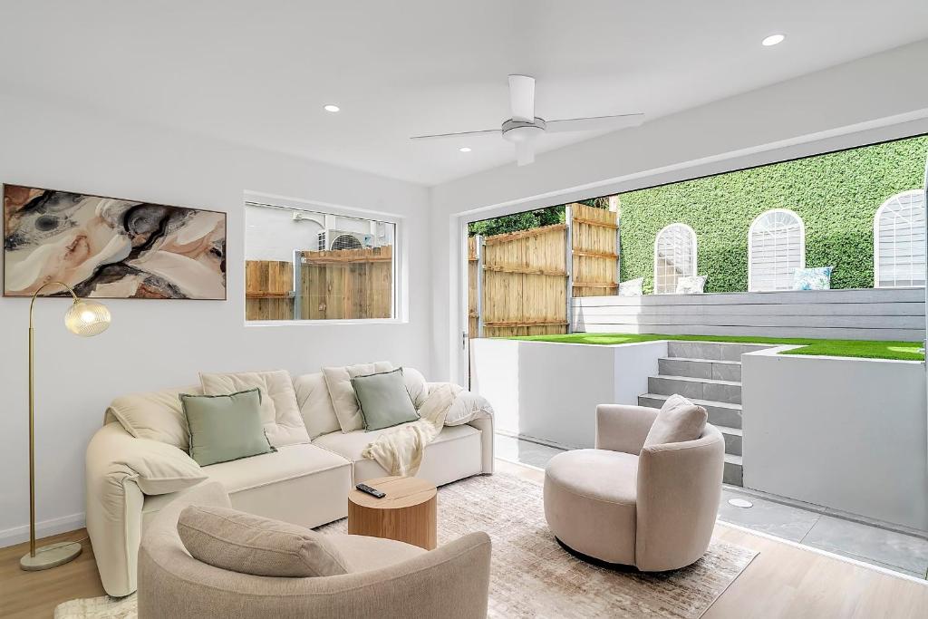 een woonkamer met een bank en 2 stoelen bij Tranquil Haven in Balmain in Sydney