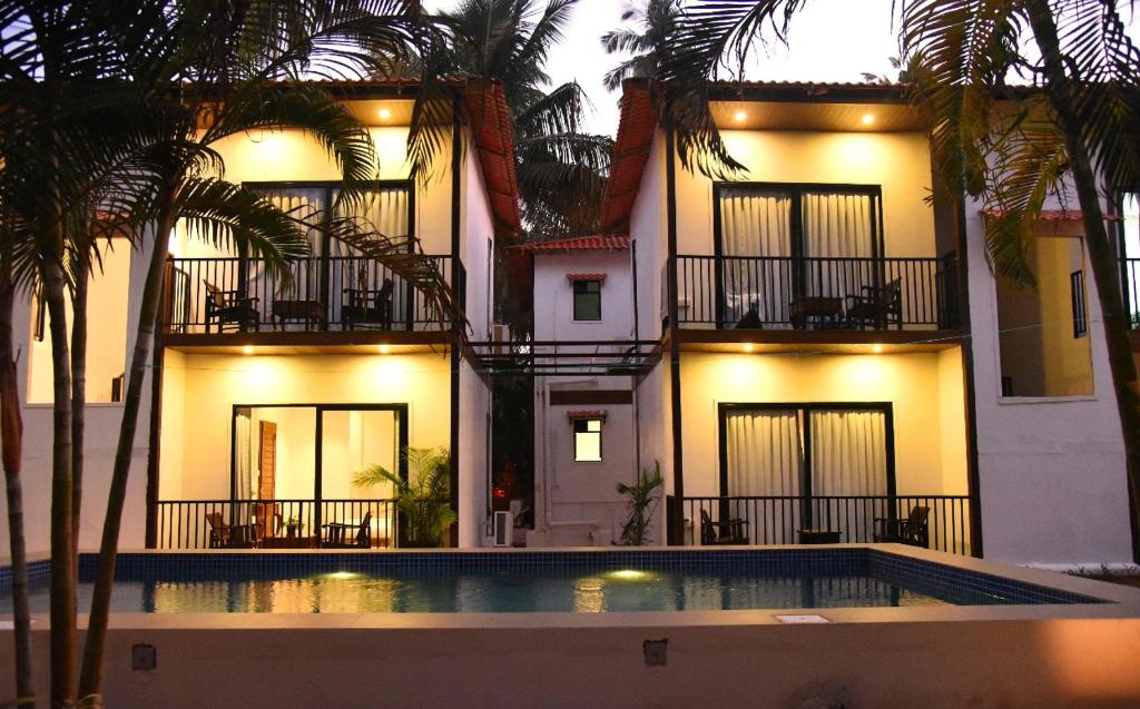 a building with a swimming pool in front of it at Arambol Sweet Lake Resort in Arambol
