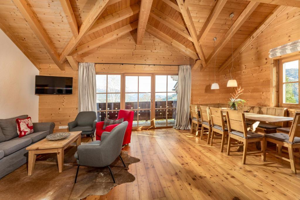 a living room with wooden ceilings and a table and chairs at Ski in/Ski out Chalets Tauernlodge by Schladming-Appartements in Schladming