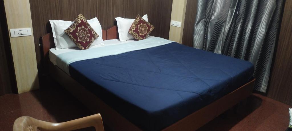 een slaapkamer met een bed met blauwe lakens en kussens bij Misty Meadows in Ooty