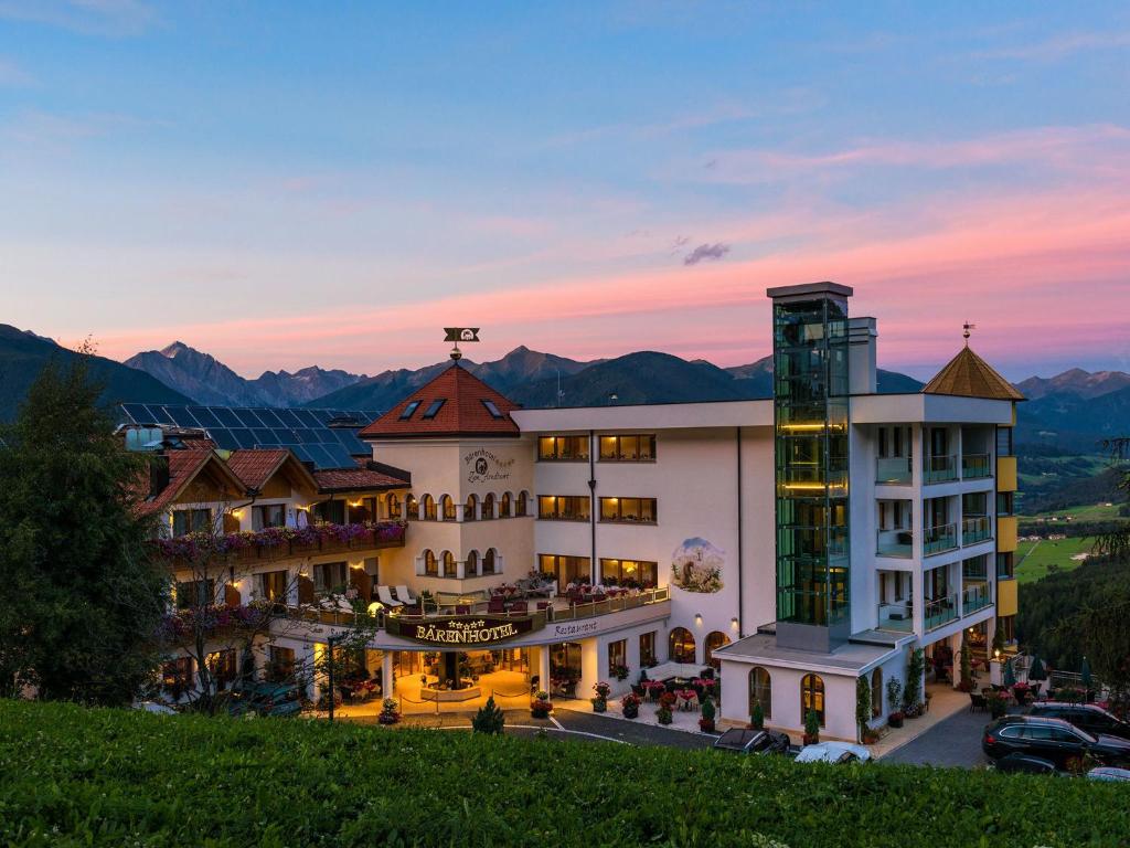 a hotel in the mountains at sunset at Bärenhotel in Valdaora