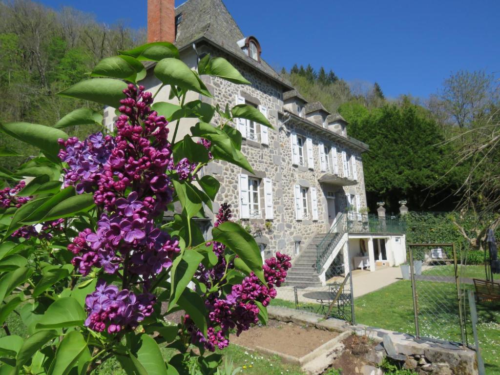 a building with purple flowers in front of it at La Demeure de Cyr 