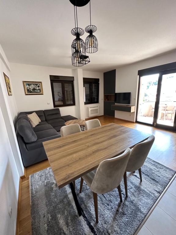 a living room with a wooden table and a couch at Apartmani Jedro in Rafailovici