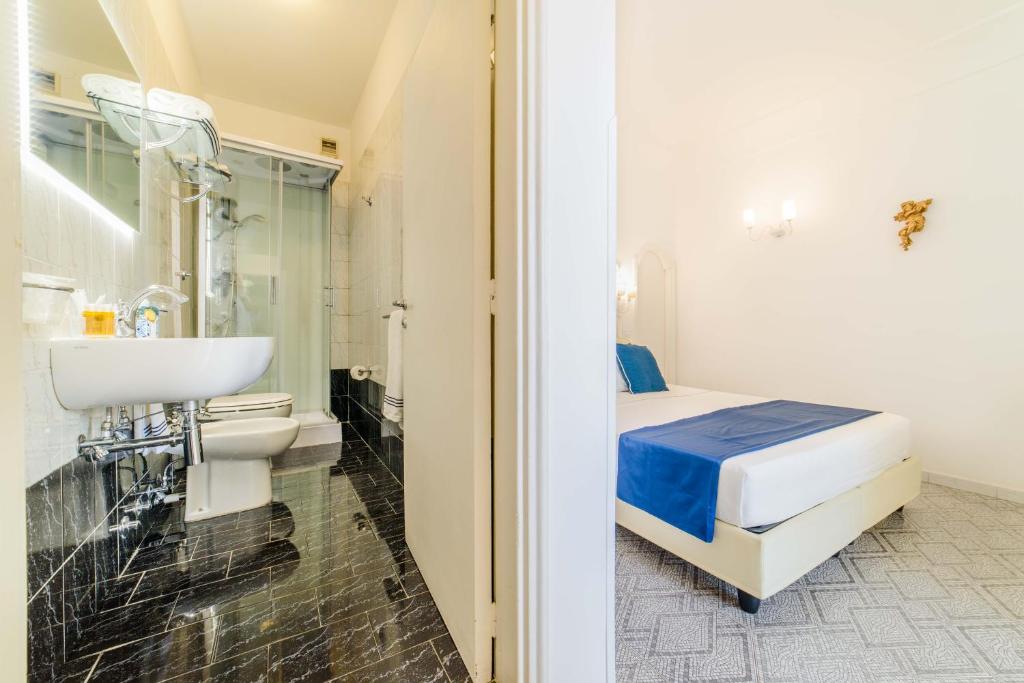bagno bianco con letto e lavandino di Residenza Al Pesce D'Oro ad Amalfi