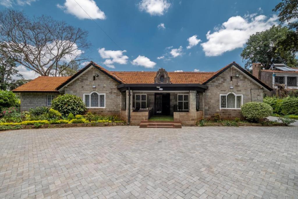 a house with a brick driveway in front of it at A PLACE OF TRANQUILITY, Muthaiga in Nairobi