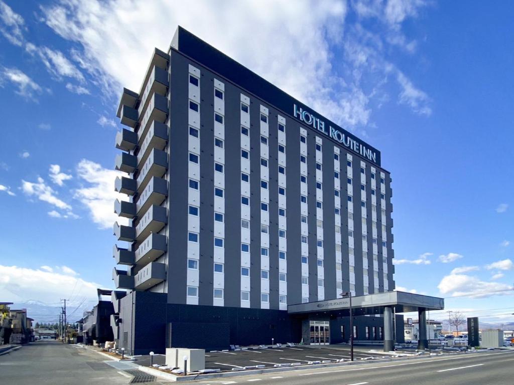 un edificio de hotel con un cartel en el costado en Hotel Route Inn Fukushima Nishi Inter, en Fukushima