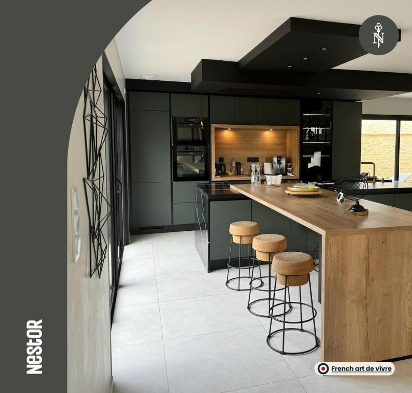 Périers-sur-le-Dan的住宿－Villa Verde — Jacuzzi, Moderne & Convivial，厨房配有绿色橱柜和带凳子的台面
