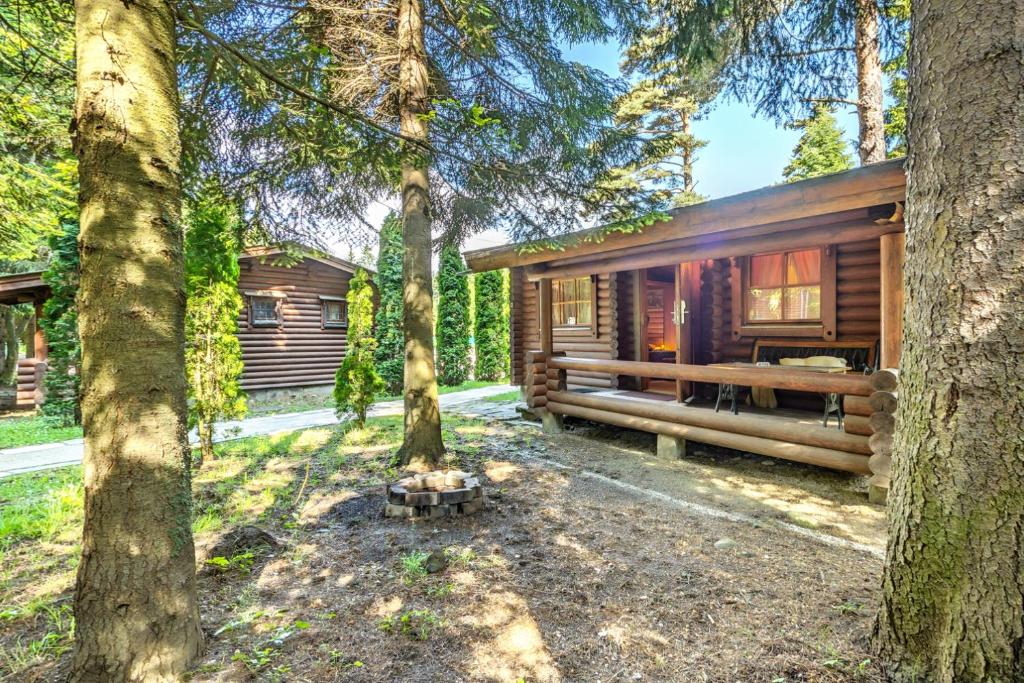 a log cabin in the woods with trees at Villas Jagoda & Malina in Borovets