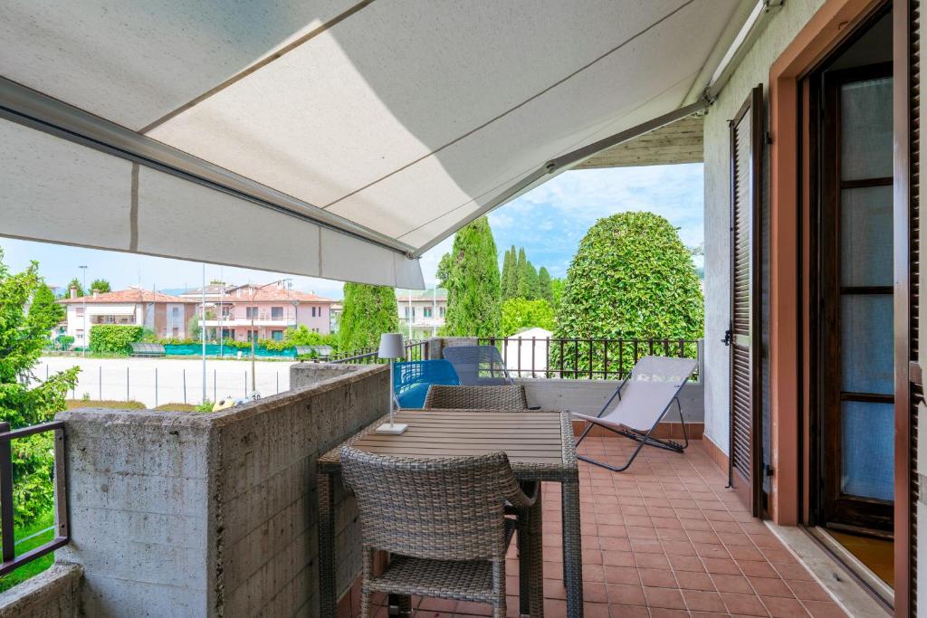 a patio with a table and chairs on a balcony at Sara al Lago - con garage e WiFi in Sirmione