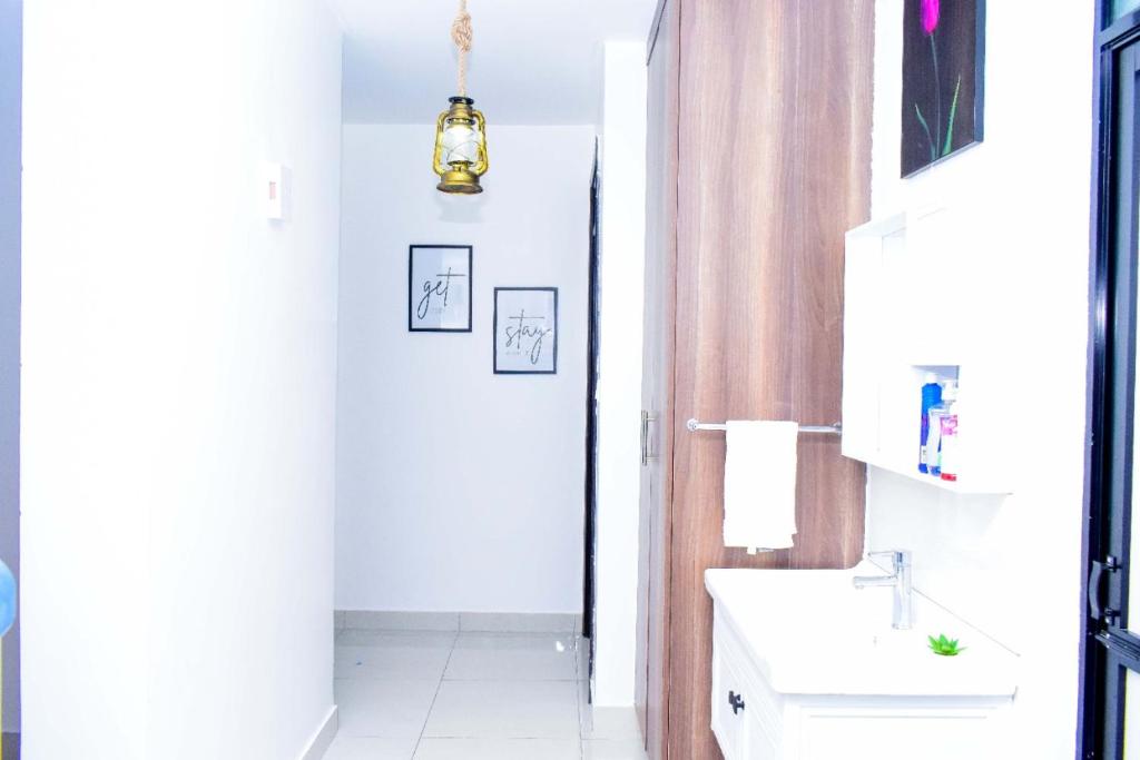 a white bathroom with a sink and a mirror at Amalia Apartments Syokimau in Machakos