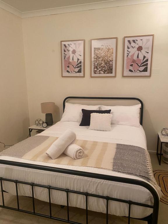 uma cama num quarto com três fotografias na parede em Riverside Boutique Apartment em Rockhampton