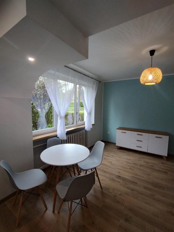Zimmer mit einem Tisch, Stühlen und einem Fenster in der Unterkunft Apartament na Mazurach -Ryn in Ryn