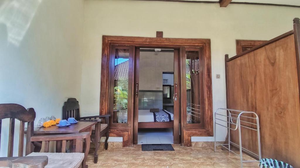 a living room with a wooden door and a table at Pala House in Ubud