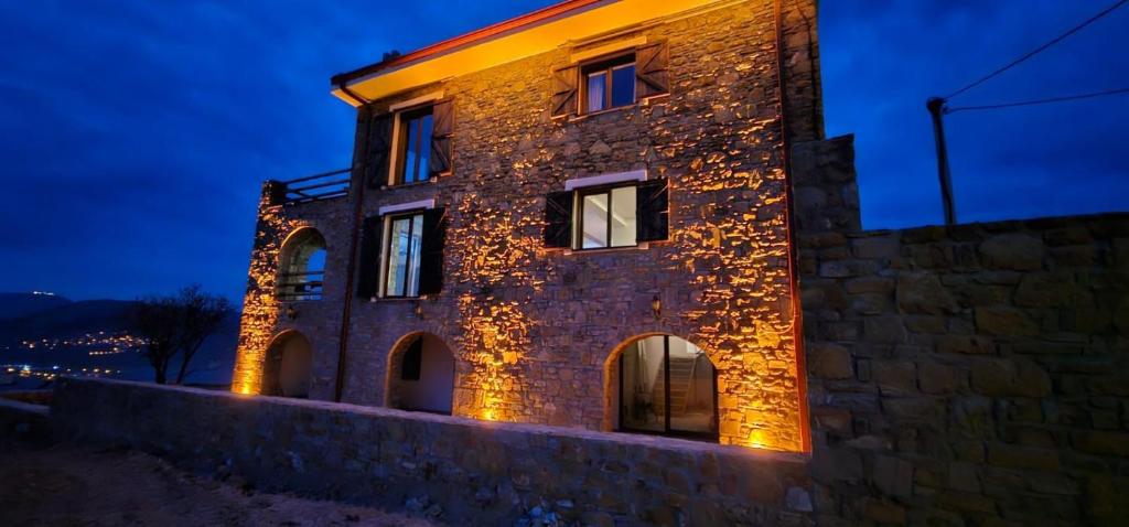 un edificio in pietra con luci accese di notte di Villa Toscana a Gokceada Town