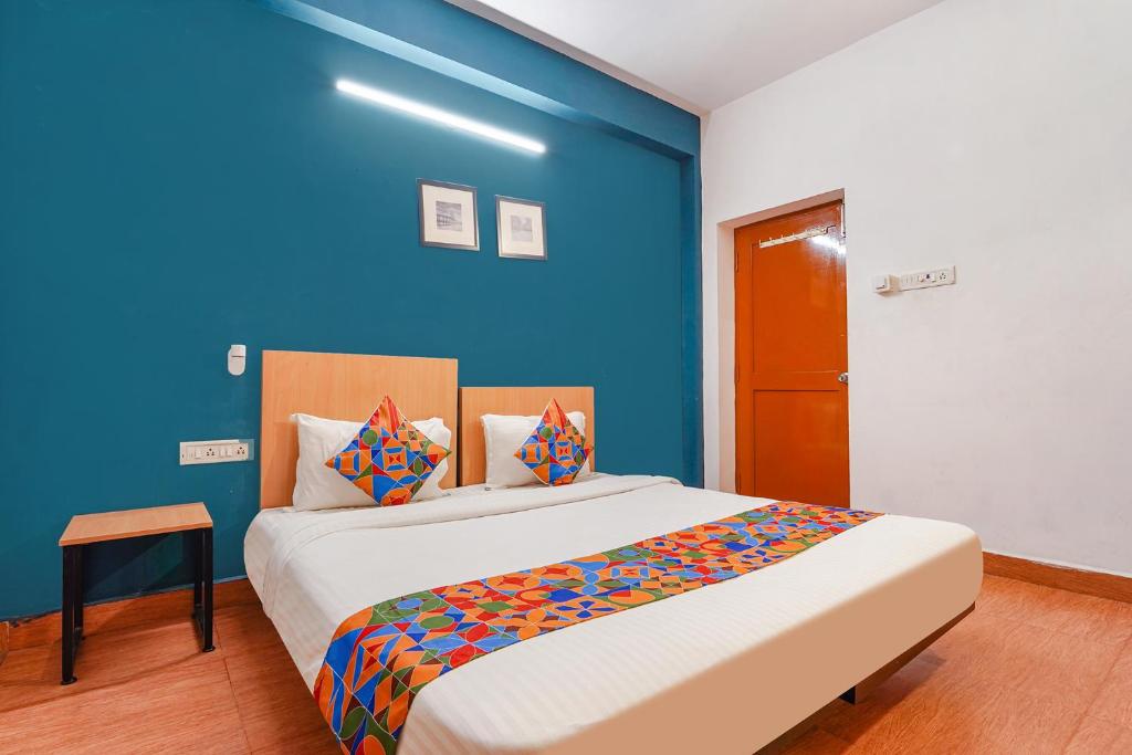 a bedroom with a large bed with a blue wall at FabExpress Harma Residency in Chennai