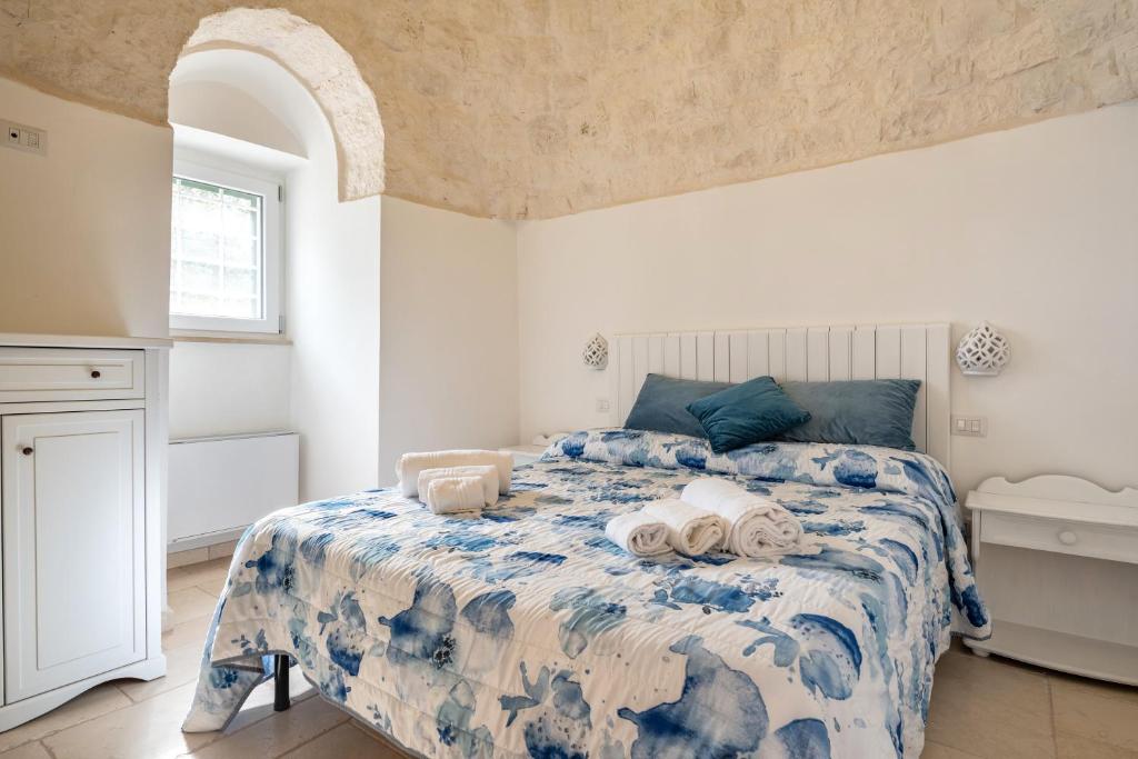 a bedroom with a bed with towels on it at Trullo degli Anelli in Masseria in Cisternino