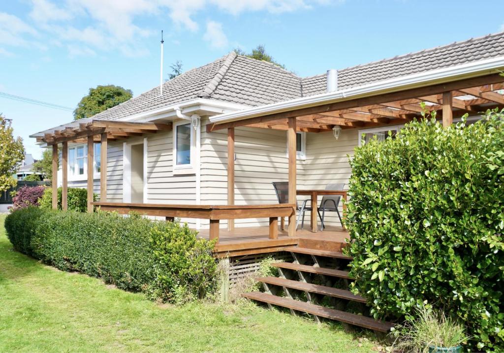 a house with a wooden deck with a table at Comfortable Home, Big Backyard in Rotorua