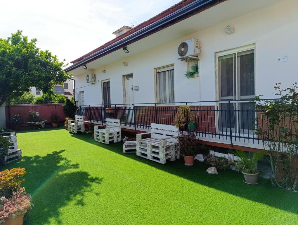 a house with a green yard with benches on it at Casa con ampio giardino e patio in Acerra