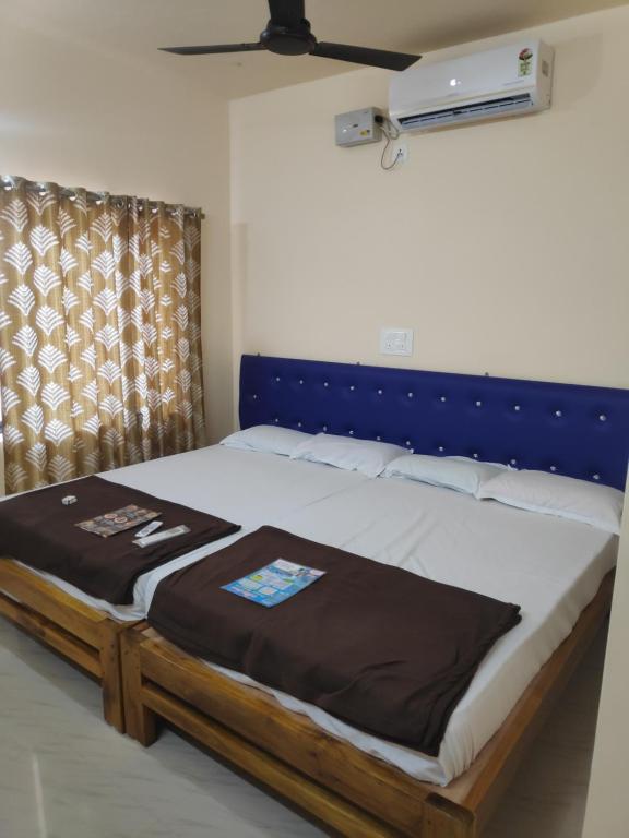 uma cama com uma cabeceira azul num quarto em Redkar Rooms Gokarna Beach front AC And Non AC Rooms em Gokarn