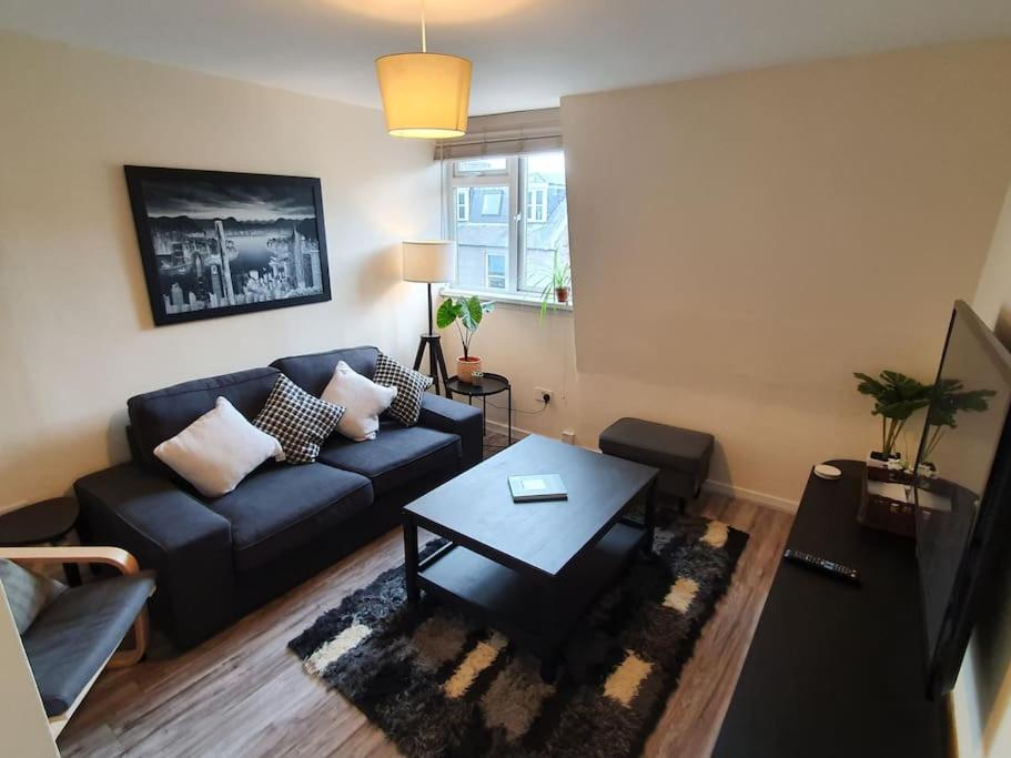 a living room with a couch and a coffee table at Lovely, comfortable and bright 3 bedroom top floor flat in City Centre in Aberdeen