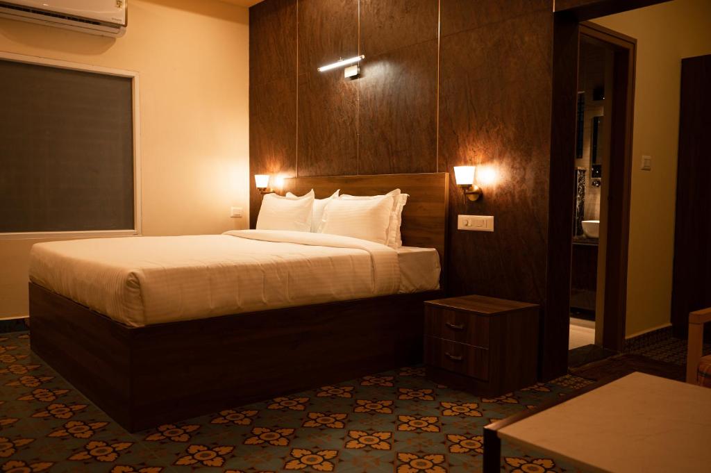 una camera d'albergo con letto e tavolo di Poojari’s Nirantara - Kabini a Hampāpura