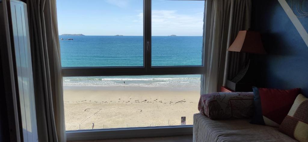een kamer met uitzicht op het strand door een raam bij Appart n°22, VUE MER, Plage in Perros-Guirec
