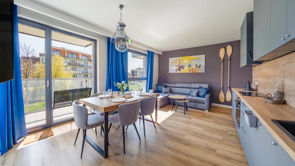 a kitchen and living room with a table and chairs at Apartamenty Sun & Snow Kaszubska Bryza ll in Hel