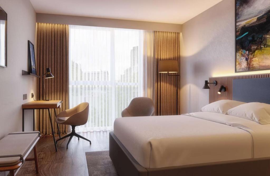 シェフィールドにあるRadisson Blu Hotel, Sheffieldのベッドと大きな窓が備わるホテルルームです。
