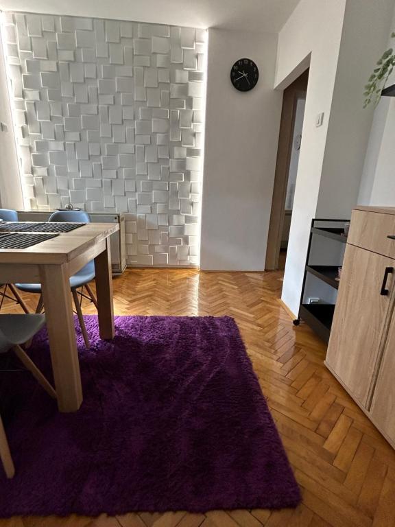 ein Esszimmer mit einem Tisch und einem lila Teppich in der Unterkunft Martina Lux in Belgrad