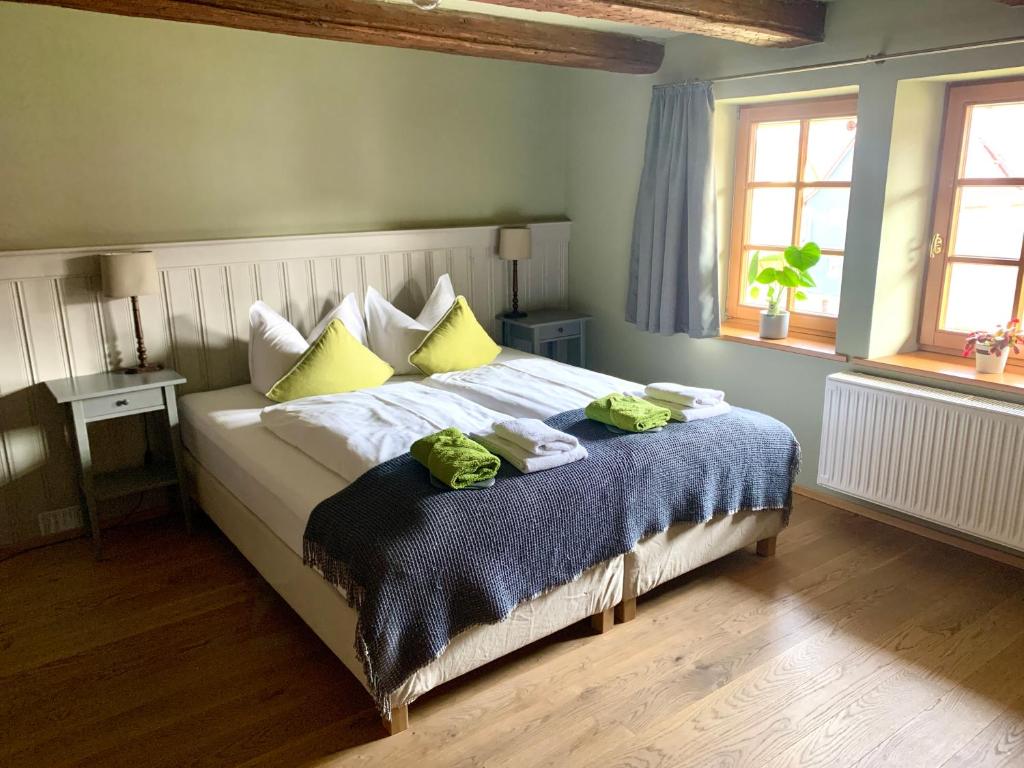 - une chambre avec un grand lit et des oreillers jaunes dans l'établissement Landhotel Ruhepol - garni, à Arnstadt