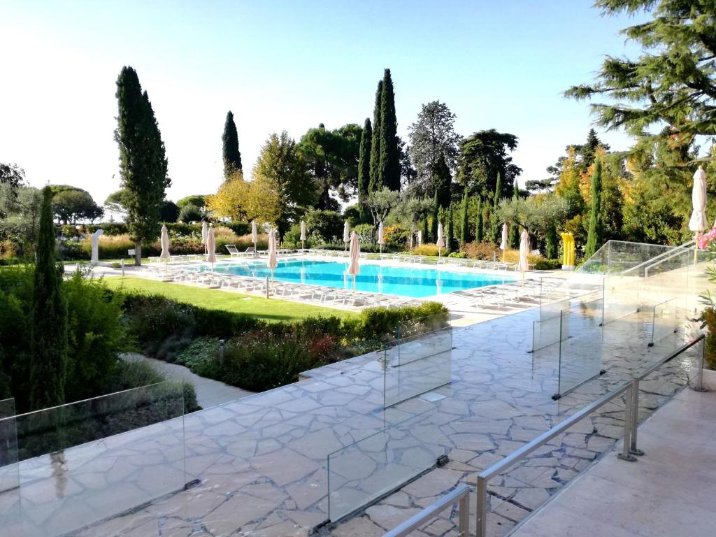 einen Pool in einem Garten mit einem Brunnen in der Unterkunft GARDA BLUE HOME - Piscina, Solarium e Box in Toscolano-Maderno