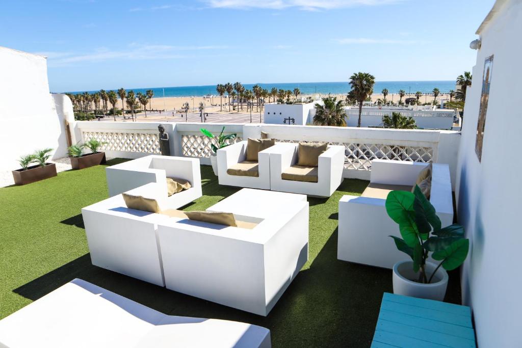 a balcony with white furniture and the beach at Valencia Luxury - Malvarrosa Beach in Valencia