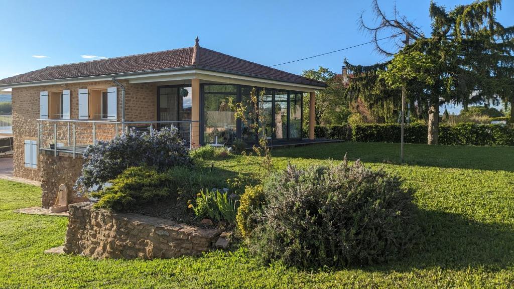 una casa con un jardín delante de ella en Alix au pays des Pierres Dorées, en Alix