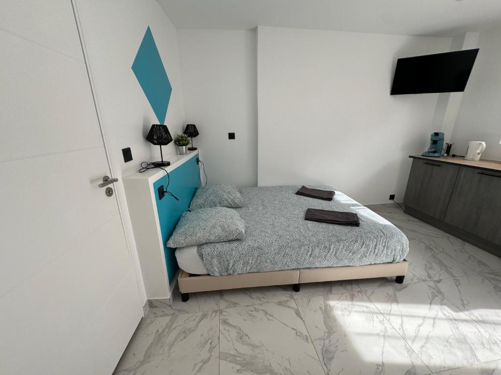 a bedroom with a bed with a blue headboard at La maison de Giulia Menton in Menton