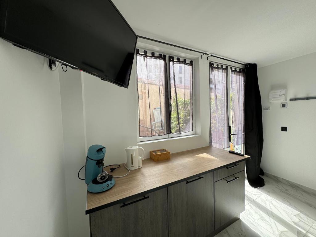 a kitchen with a counter with a tv on the wall at La maison de Giulia Menton in Menton