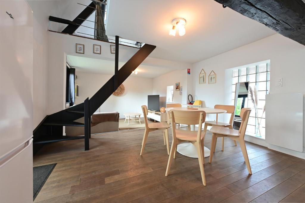 uma sala de jantar e sala de estar com mesa e cadeiras em Le Relais à 7 minutes du Centre de Lille em Marcq-en-Baroeul