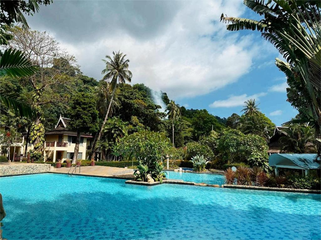 a large blue swimming pool in front of a house at Bhumiyama Plus in Ko Chang