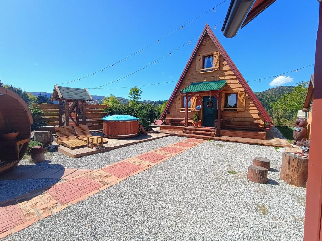 eine Blockhütte mit einer Terrasse und einem Pavillon in der Unterkunft Mountain guest house “Fajeri” in Brestova Draga