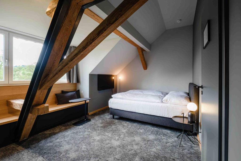 1 dormitorio en el ático con 1 cama y TV en Ben Hogan Lodge, en Owingen