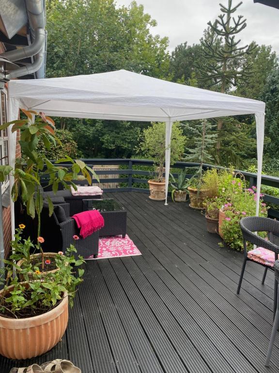 une tente blanche sur une terrasse avec des plantes en pot dans l'établissement Bøllingsø Bed and Breakfast, à Engesvang