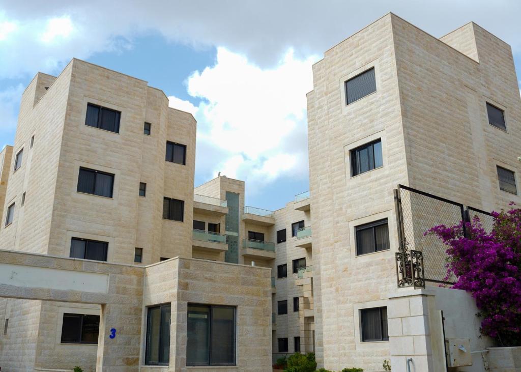 un grand bâtiment en briques avec un ciel dans l'établissement مجمع الحدائق, à Amman