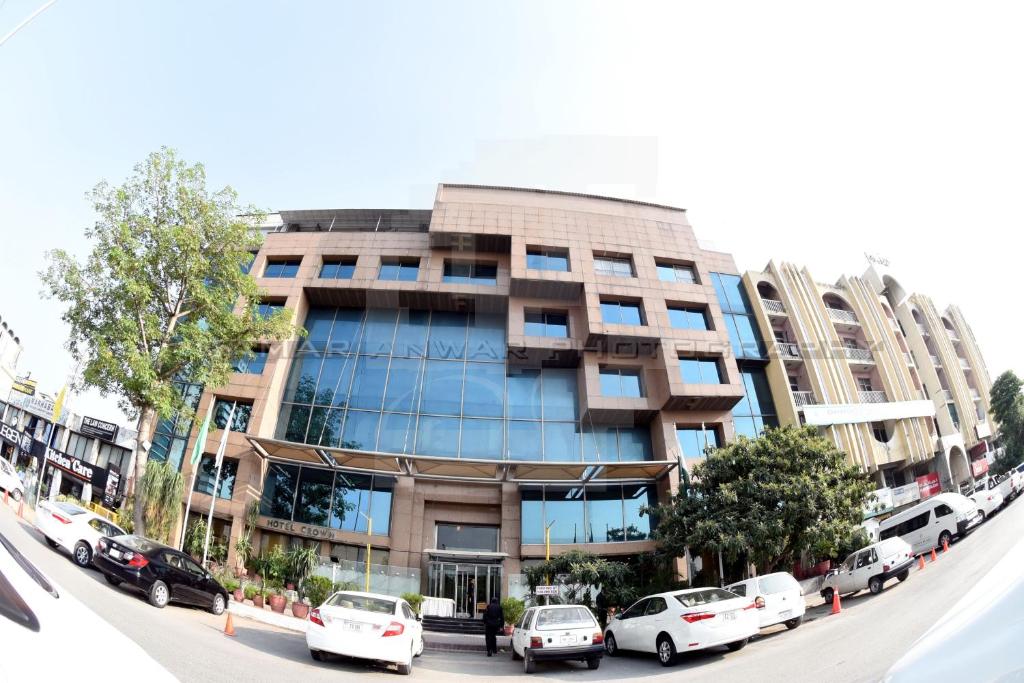 a building with cars parked in front of it at Hotel Crown Plaza Islamabad in Islamabad