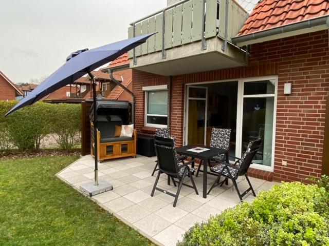 a patio with a table and chairs and an umbrella at FeWo kleine Auszeit in Cuxhaven