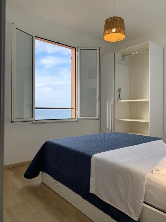 ein Schlafzimmer mit einem großen Bett und einem Fenster in der Unterkunft Affacciati al mare in Finale Ligure