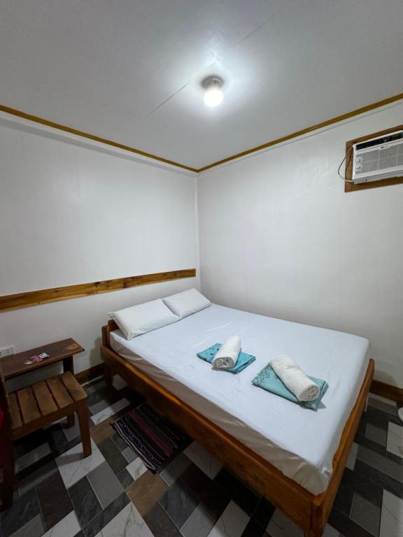 a bedroom with a bed with two pillows on it at Bearbys Homestay Siargao - B in Catangnan